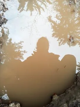 Boy reflected in a puddle  Stock Photos