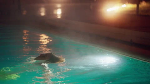 Boy Relaxing in a Lit Pool at Night Stock-Footage 335401998