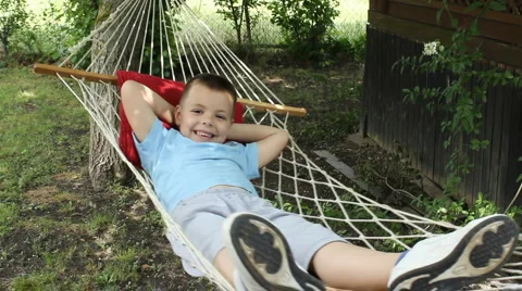 Boy relaxing on rope hammock Stock Footage 5958992