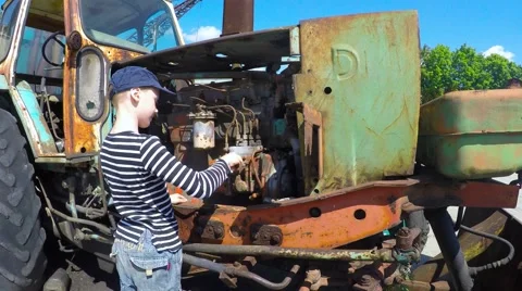 Boy repairing the engine in the tractor Stock-Footage 51396176