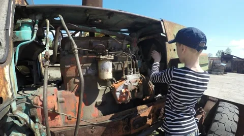 Boy repairing the engine in the tractor Stockbeeldmateriaal 51396188