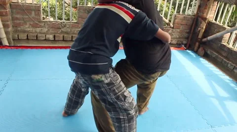 Boy resists as another practices a take-down on him,practicing jiu jitsu Stock Footage 58466551