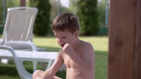 Boy resting and taiking sunbathe on a lounger in the aquapark near the pool Stock Footage 80767920