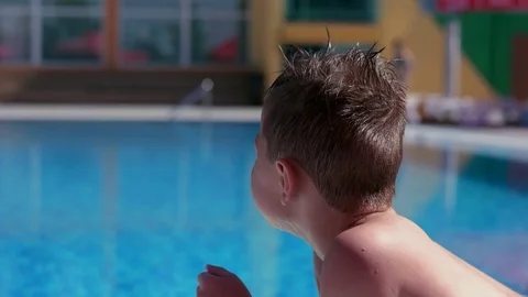 Boy resting and taiking sunbathe on a lounger in the aquapark near the pool Stock Footage 80770325