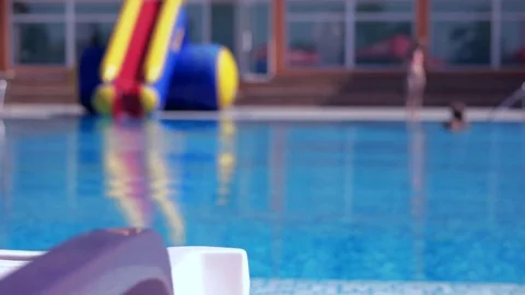 Boy resting and taiking sunbathe on a lounger in the aquapark near the pool Stock Footage 80770607