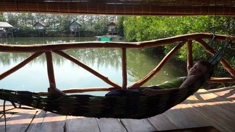Boy resting in hammock Stockbeeldmateriaal 115119812