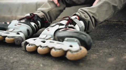 The boy is resting sitting at the edge of the road in roller skates Stock Footage 131281124