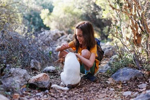 Boy rests while trekking and plays with a dog... A boy with a backpack plays  Stock Photos