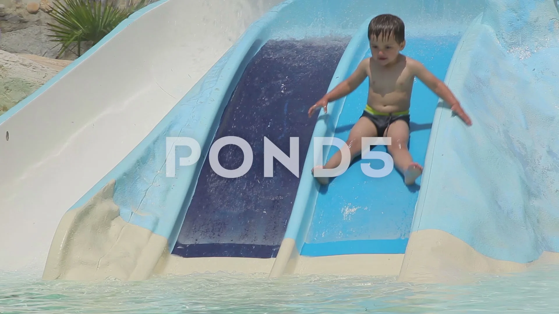 Boy ride the roller coaster in the pool