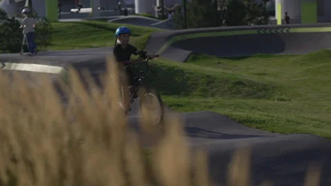Boy rides bicycle along specially designed park path 動画素材 326455282