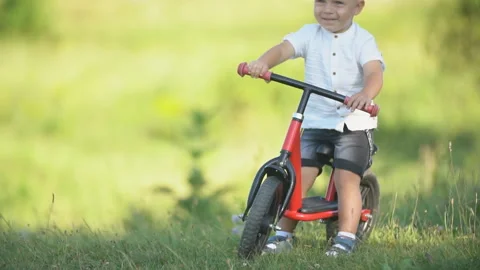A boy rides a bicycle without pedals Stock Footage 113456854