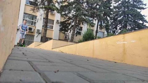 A boy rides a scooter down a hill Stock Footage 196631805