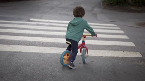 Boy riding across the road on pedestrian crossing Stock Footage 113446845