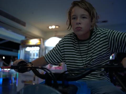 Boy riding an arcade motorcycle game Stock Photos