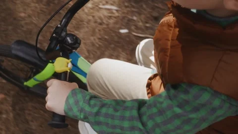 Boy riding bicycle in forest close view of torso and handlebar Stock Footage 315756290
