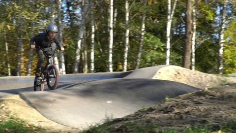 Boy riding a bicycle on a pumptrack Stock Footage 118890894