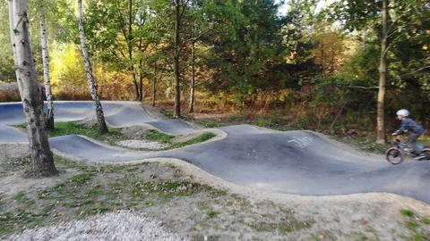 Boy riding a bicycle on a pumptrack Stock Footage 118890983