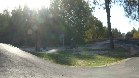 Boy riding a bicycle on a pumptrack Stock Footage 118891011