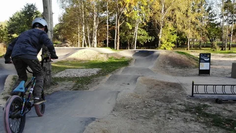 Boy riding a bicycle on a pumptrack Stock Footage 118891148