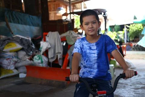 Boy Riding Bicycle in a Rustic Environment Stock Photos