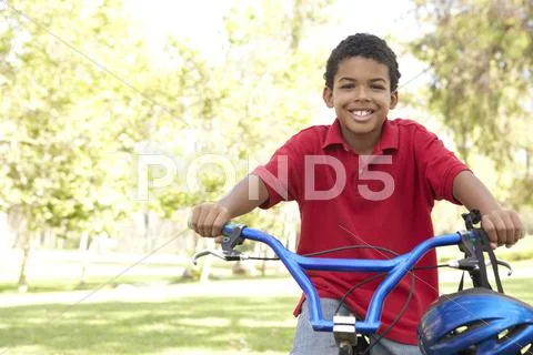 Boy Riding Bike In Park Stock Photos