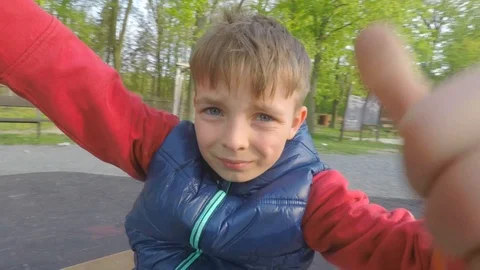 A boy riding a carousel, showing like gestures and Horns Stock Footage 115098621