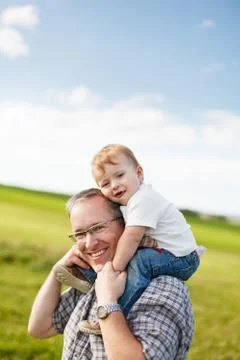 Boy riding his father's shoulders Stock Photos