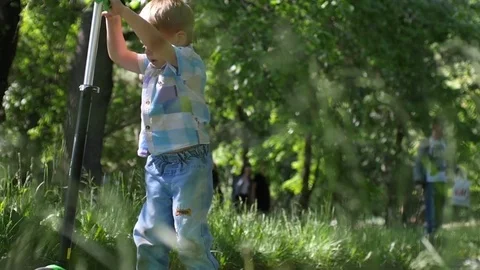 Boy riding mini kick scooter in the park and father comes to his son in slow 스톡 동영상 79686854