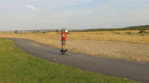 Boy Riding OneWheel Left to Right HD Stock Footage 97665050