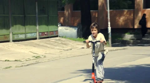 Boy riding scooter Stock Footage 63405650
