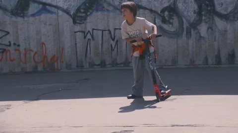 Boy riding scooter Stock Footage 63431293