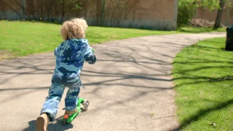 The boy is riding a scooter in the park Stock-Footage 76000597