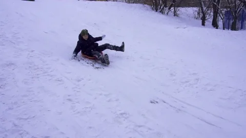 Boy riding on a snow hill. Winter fun. Slow motion Stock Footage 100579367
