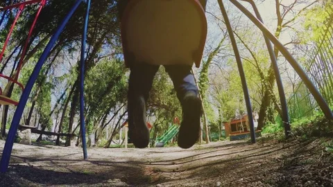 The boy is riding on a swing in the playground 스톡 동영상 75560940