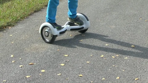Boy riding on a white hoverboard, on a small road in the countryside Stock Footage 103596713