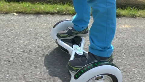 Boy riding on a white hoverboard, on a small road in the countryside Stock Footage 103597049