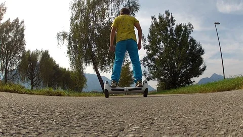 Boy riding on a white hoverboard, on a small road in the countryside Video stock 103598986