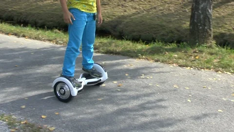 Boy riding on a white hoverboard, on a small road in the countryside Stock Footage 103600193
