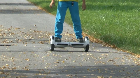 Boy riding on a white hoverboard, on a small road in the countryside Stock Footage 103670049