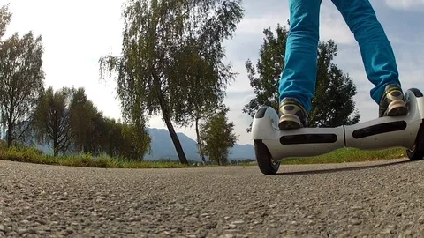 Boy riding on a white hoverboard, on a small road in the countryside Stock Footage 103671974