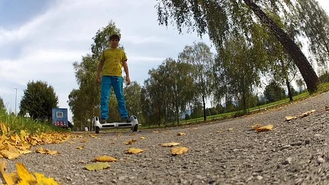Boy riding on a white hoverboard, on a small road in the countryside Stock Footage 103677910