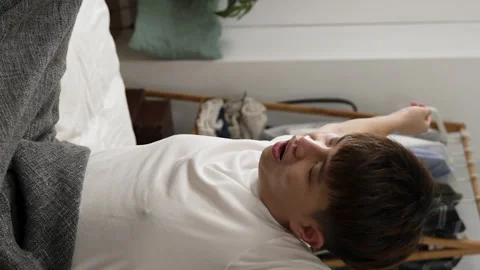 Boy rising quickly from bed in the morning Stock Footage 229621823