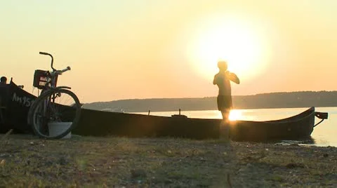 Boy on the river sunset Stock Footage 10855572