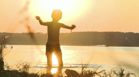 Boy on the river sunset Video stock 10855586