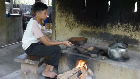 Boy roasts coffee beans on pan woman pounds with pestle Video stock 102488991