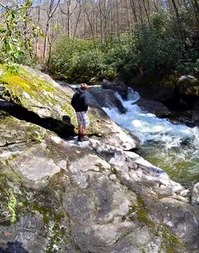 Boy on rocks at a river Stock Photos