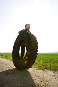 Boy rolling big tire Stock Photos