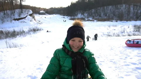 The boy rolls down the mountain on an inflatable sled Video stock 85929531