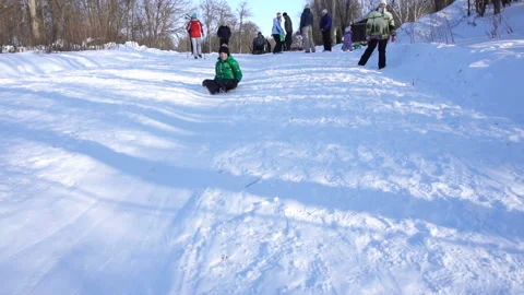 The boy rolls down the mountain in the snow Video stock 85919787