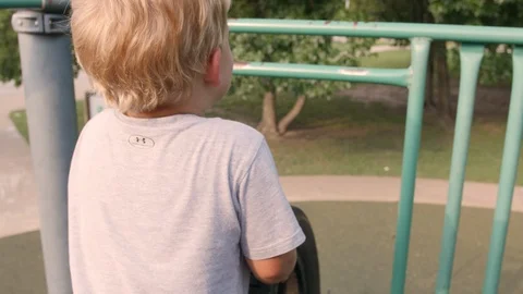 Boy Rolls Tire Down Metal Park Slide Video stock 98916376